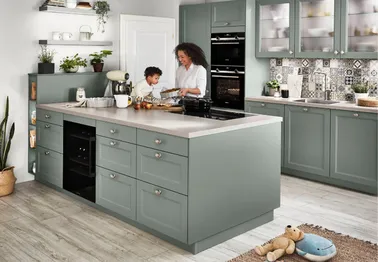 Mutter und Sohn backen an grüner Inselküche Mutter und Sohn backen an grüner Inselküche